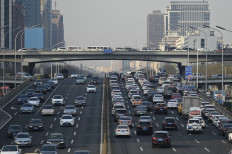Vehicles move along a street at Central Business District (CBD) in Beijing on Jan. 16, 2024.