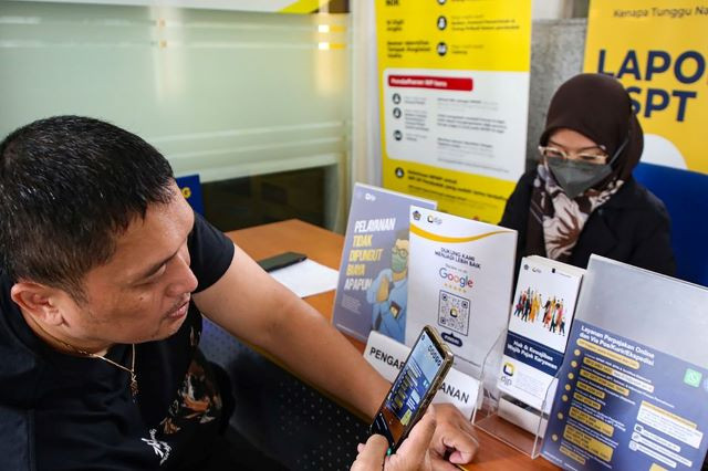 Going online: A taxpayer takes a picture of the guideline for requesting online taxation services at a counter at the Kebayoran Baru 1 branch of the tax office in South Jakarta on Nov. 20, 2023. 