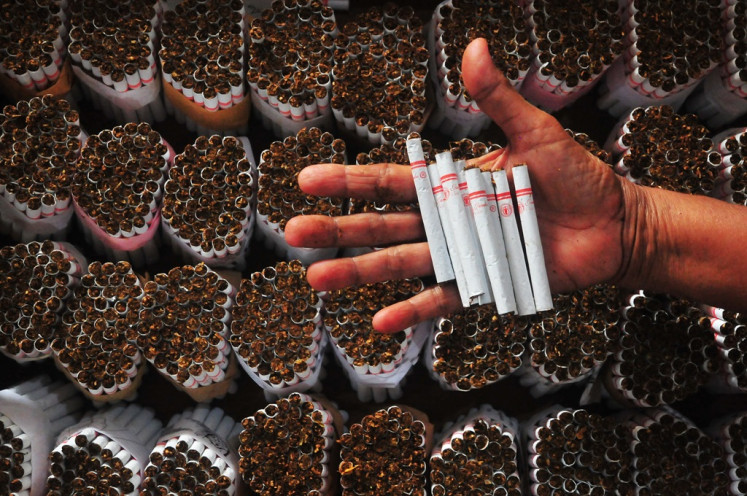 A worker shows hand-rolled kreteks (clove cigarettes) on Jan. 4, 2024, at a cigarette factory in Kudus, Central Java.