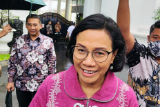 Finance Minister Sri Mulyani Indrawati greets journalists on Jan. 19, 2024 after a meeting at Merdeka Palace in Central Jakarta.
