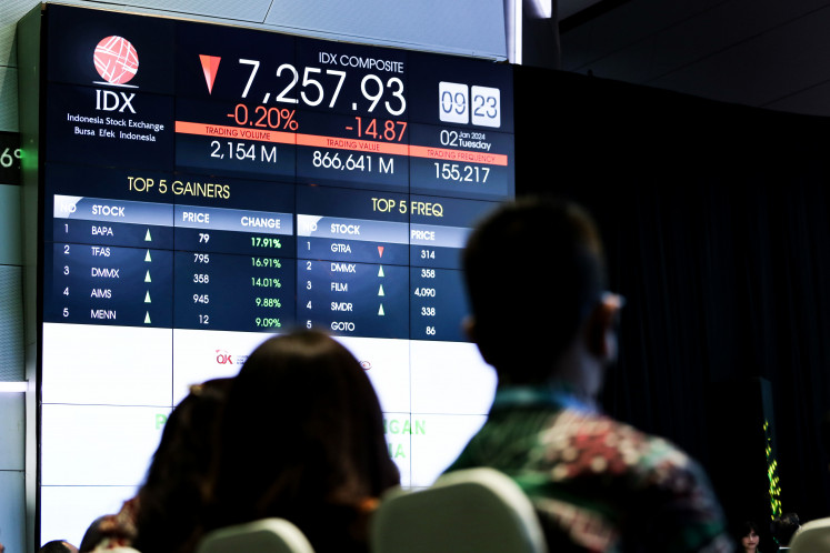 Attendees look at stock trading movements during the trade opening ceremony at the Indonesia Stock Exchange (IDX) in Jakarta on Jan. 2, 2024. The IDX Composite dropped by 0.53 percent to 7,296.70 on Feb. 19, 2024, as investors await Bank Indonesia's interest rate decision this week.