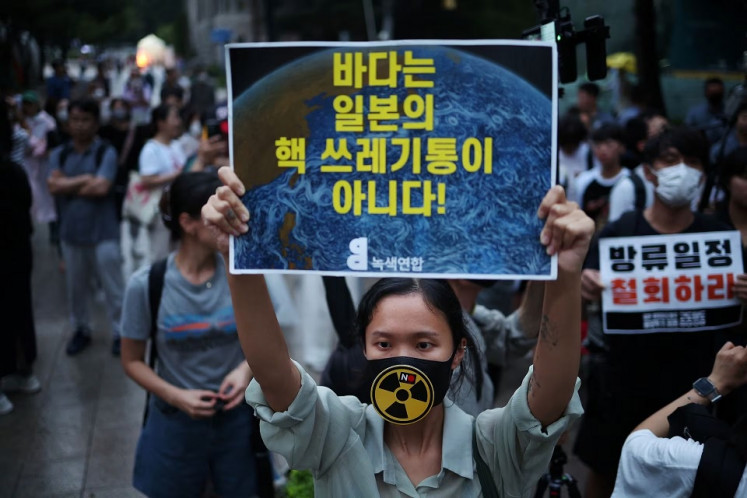Nuclear nixed: A woman holds up a placard reading, &ldquo;The ocean is not a trash bin for nuclear waste!&ldquo; during a protest on Aug. 22, 2023,  in central Seoul.
