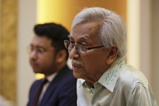 Malaysia's new government advisor Daim Zainuddin (right) speaks during a meeting with China's Foreign Minister Wang Yi (not pictured) at the Ministry of Foreign Affairs in Beijing on July 18, 2018.