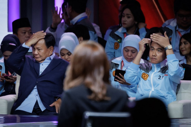 Presidential candidate and Defense Minister Prabowo Subianto (left) and vice presidential candidate and Surakarta Mayor Gibran Rakabuming Raka (right) react during the second vice presidential election debate at the Jakarta Convention Center (JCC) in Jakarta on Jan. 21, 2024.