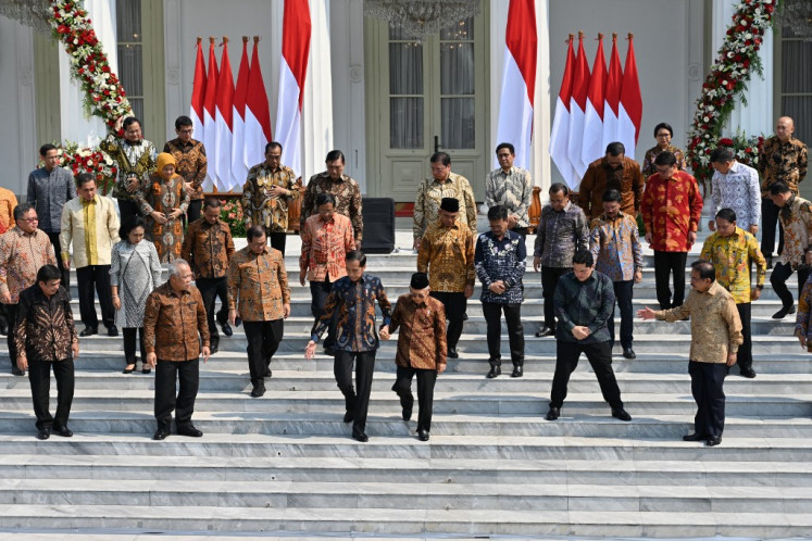 President Joko “Jokowi“ Widodo (center left, foreground) walks hand-in-hand with Vice President Ma'ruf Aminto to their positions on the steps of Merdeka Palace in Jakarta on Oct. 23, 2019, prior to taking a “family photo” with members of the Onward Indonesia Cabinet.