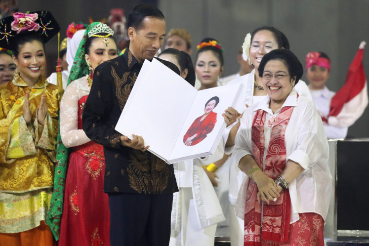 Megawati Sukarnoputri presents a book about herself titled “The Brave Lady“ to President Joko “Jokowi“ Widodo during her birthday celebration in Jakarta on January 23, 2019.