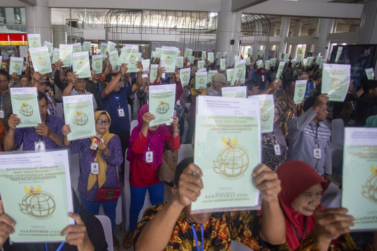 Residents shows land certificates received through the comprehensive systematic registration program (PTSL) on Jan. 26, 2024, at Kertajati Airport in Majalengka, West Java. The Agrarian and Spatial Planning Ministry aims to distribute 120 million land certificates through the PTSL program by the end of 2024.