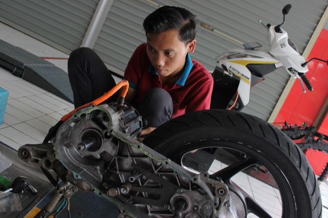 A mechanic installs electric components on Jan. 12, 2024 while converting an internal combustion engine motorcycle into an electric one at the Bintang Racing Team garage in Bogor regency, West Java.