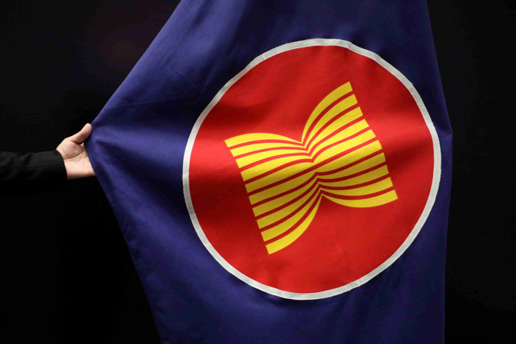 A worker adjusts an ASEAN flag at a meeting hall in Kuala Lumpur on Oct. 28, 2021.