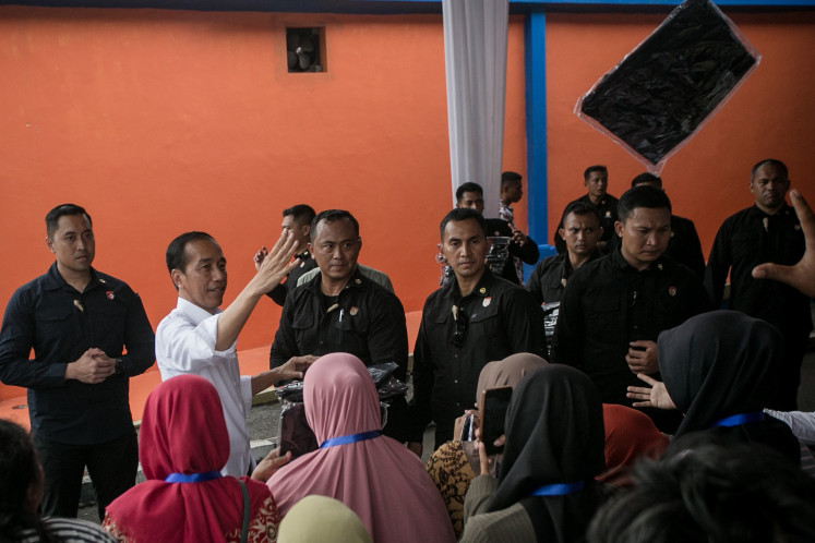President Joko “Jokowi“ Widodo (second left) throws T-shirts to local residents of Telukan village in Sukoharjo, Central Java, on Feb. 1, 2024, during a work visit in the region. During the visit, Jokowi began the disbursement of 10 kilograms of rice to 22 million low-income people until June.
