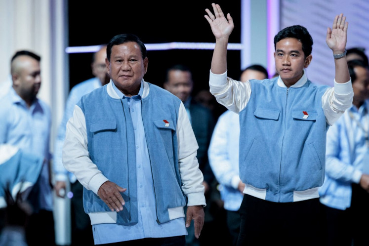 Presidential candidate and Defense Minister Prabowo Subianto (left) and vice presidential candidate Gibran Rakabuming Raka react during the last presidential election debate at the Jakarta Convention Center (JCC) in Jakarta on Feb. 4, 2024.
