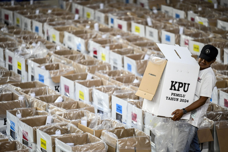 A local poll administrator (KPPS) moves a ballot box at the North Jakarta Elections Commission (KPU) logistics warehouse at Cempaka Putih sports hall in Jakarta on Feb. 5, 2024.