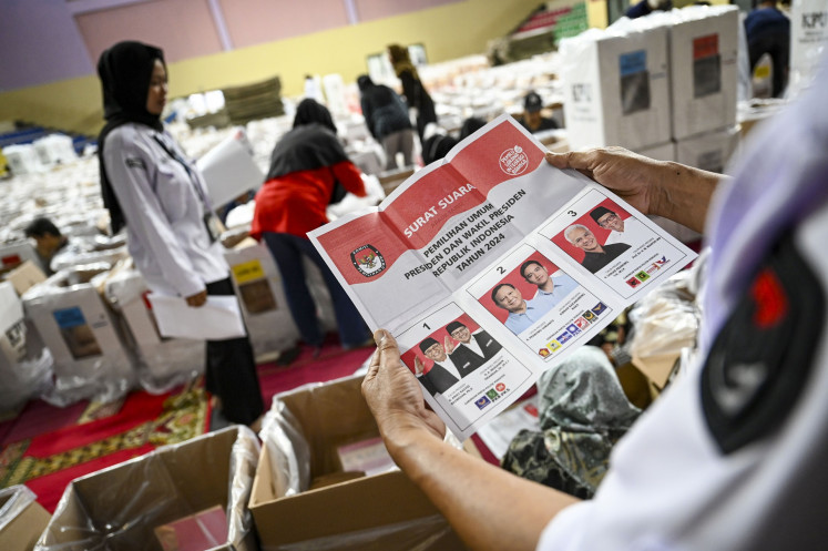 A General Elections Commission (KPU) official checks a presidential election ballot at a logistics warehouse at Cempaka Putih Sports Hall in Central Jakarta on Feb. 5, 2024.