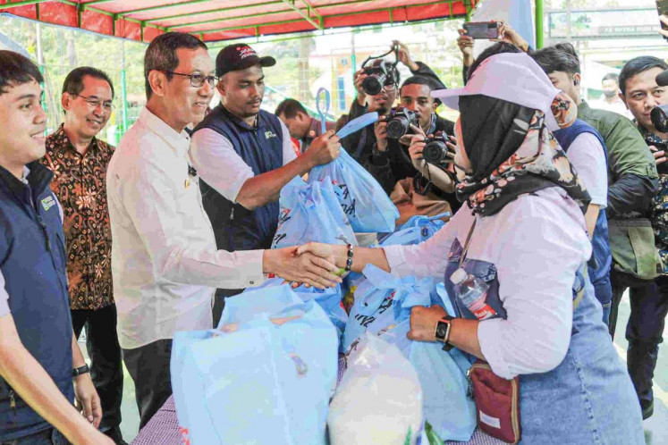 Acting Jakarta governor Heru Budi Hartono (third left) shakes hands with a resident while monitoring a cheap grocery market in Koja subdistrict, Koja district, North Jakarta, on Feb. 2, 2024. Heru has denied allegations that cheap basic grocery markets held across the city on Feb. 7, 2024, were related to the presidential election, saying they were merely intended to help the people.