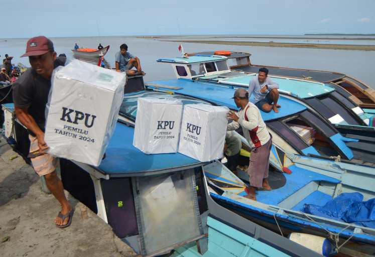 Workers unload ballot boxes from a boat in Muara Siberut, Mentawai Islands regency, West Sumatra, on Feb. 10, 2024.
