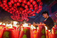 A worshipper lights a candle on Feb. 9, 2024, the eve of Chinese New Year, at Toa Se Bio Temple in Glodok, West Jakarta.