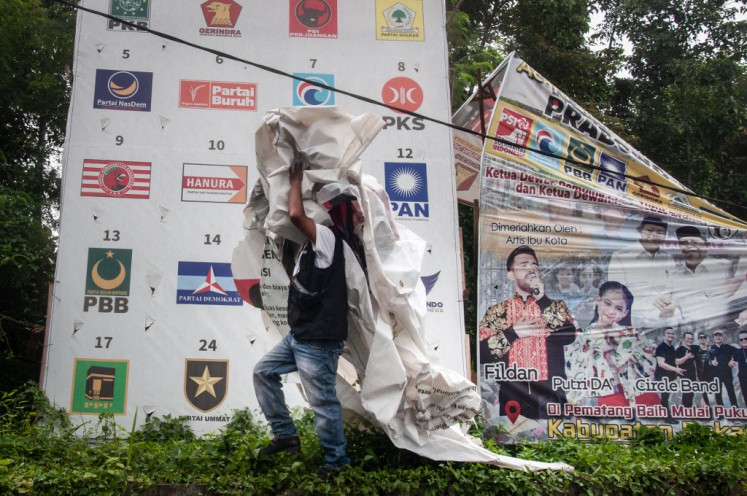 Staff of the General Elections Supervisory Agency (Bawaslu) take down campaign banners at the end of the campaign period in Pekanbaru, Riau, on Feb. 11, 2024, ahead of Indonesia's upcoming general election scheduled to be held on Feb. 14.