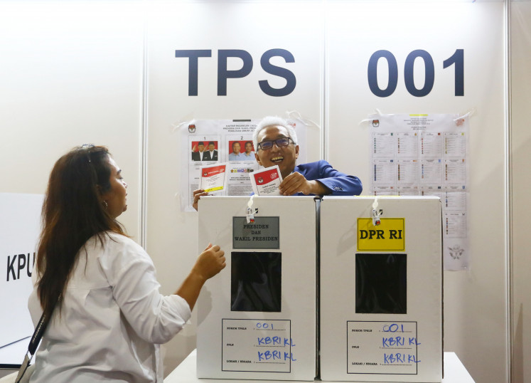 Indonesian Ambassador for Malaysia Hermono inserts ballot papers into ballot boxes after casting his vote at a polling station at Kuala Lumpur World Trade Center in Malaysia on Feb. 11, 2024.