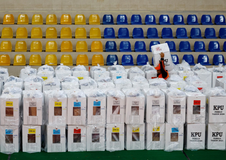 A worker carries a ballot box for distribution to polling stations at a distribution center in Jakarta on Feb. 13, 2024 ahead of the voting day of the 2024 general election on Feb. 14.