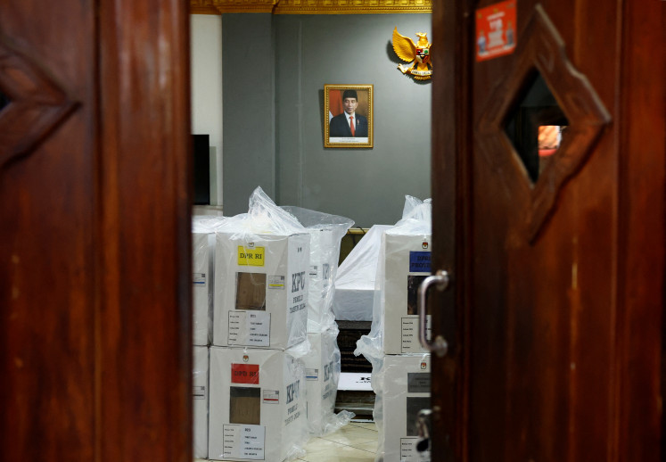Ballot boxes are kept in a room where the portrait of President Joko “Jokowi“ Widodo is hung on the wall, at a polling station ahead of the presidential election in Jakarta, Indonesia, February 13, 2024.