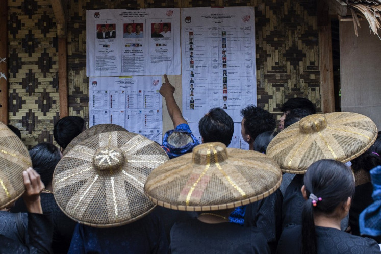 Members of the indigenous Baduy tribe check the candidate list at a polling station on Feb. 14, 2024, before they cast their votes in Indonesia's presidential and legislative elections, in Kanekes Village, Lebak, Banten province. Voting began on Feb. 14 in Indonesia's presidential, national and provincial elections at more than 800,000 polling stations across the country, with nearly 205 million people eligible to vote. 