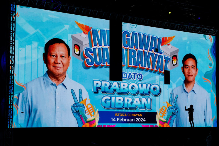 A worker checks a large screen showing presidential candidate Prabowo Subianto and running mate Gibran Rakabuming Raka, the eldest son of outgoing President Joko “Jokowi“ Widodo before the start of an event where counting results will be displayed in Jakarta on Feb. 14, 2024.