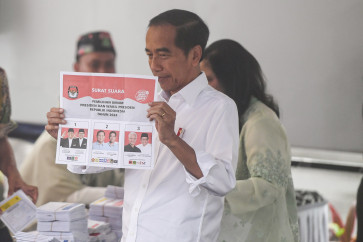 President Joko “Jokowi” Widodo shows his ballot paper for the 2024 presidential election at a polling station in Central Jakarta on Feb. 14, 2024.
