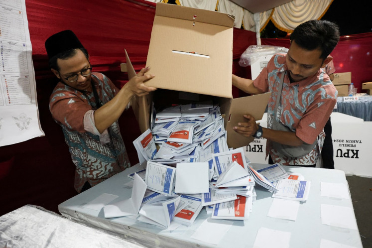 Poll workers count votes at a polling station after voting closed in Jakarta on Feb. 14, 2024. The General Elections Commission (KPU) says the delay in updating the 2024 general elections vote count on Sirekap is for the sake of data synchronization and accuracy.