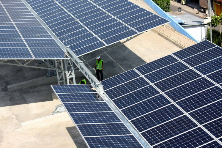 Workers check solar panels at Tirtonadi Terminal in Surakarta, Central Java, for a Transportation Ministry project capable of producing 500,000 watts of electricity to power the terminal's operations, in this undated photograph.