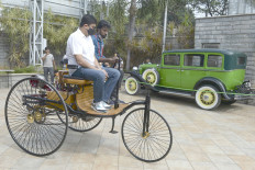 Visitors take a ride on a 1886 Benz patent Motorwagen displayed during a heritage car show in Chennai on Jan. 10, 2021. 
