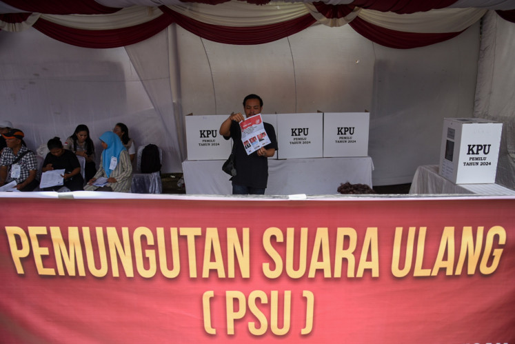 A voter folds his ballot paper during a revoting day at a polling station in Medan, North Sumatra on Feb. 21, 2024. Two polling stations in the city held a revote following 37 cases of double voting and 16 voters who failed to show their identity cards during the Feb. 14 voting day.