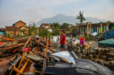 A resident stands among the debris of a house destroyed by a small tornado in Sukadana village, Sumedang regency, West Java on Feb. 22, 2024. The West Java Disaster Mitigation Agency (BPBD) recorded 97 houses and 17 factory buildings that were damaged in the disaster that broke out on Feb. 21, injuring at least 31 people.