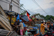 People salvage personal belongings on Feb. 21, 2024 from houses destroyed by a 'puting beliung' (whirlwind) that struck earlier that day in Rancaekek, Bandung regency, West Java. The West Java Disaster Mitigation Agency (BPBD) reported that 97 houses and 17 factories were damaged and at least 31 people were injured during the disaster.
