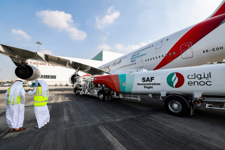 Ground crew prepare an Emirates Airbus A380-800 aircraft, powering one of its engines with a hundred per cent Sustainable Aviation Fuel (SAF), for a demonstration flight at the Dubai International Airport in Dubai on Nov. 22, 2023.