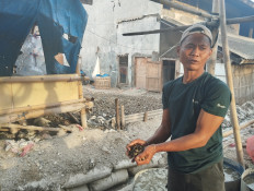 Endi Suhaendi, a 28-year-old owner of a family green mussel cultivation business, checks the shelled mussels in Dadap village, Kosambi, Tangerang regency, Banten, on Jan. 23, 2024. Endi said his team had to go as far as  Bidadari Island to find a clean enough environment to grow green mussels.