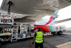 Ground crew prepare an Emirates Airbus A380-800 aircraft, powering one of its engines with a hundred per cent Sustainable Aviation Fuel (SAF), for a demonstration flight at the Dubai International Airport in Dubai on Nov. 22, 2023.