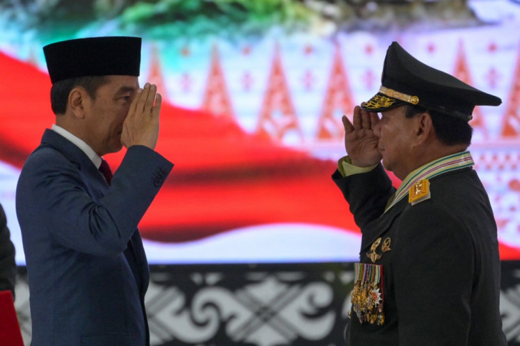 President Joko “Jokowi“ Widodo (center) awards Defense Minister Prabowo Subianto (right) the rank of honorary four-star general in Jakarta on Feb. 28 2024.