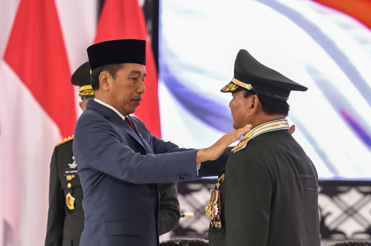 President Joko “Jokowi“ Widodo (left) pins shoulder scales bearing the insignia of honorary general on Defense Minister Prabowo Subianto (center) in a ceremony in Jakarta on Feb. 28, 2024. The event was held during an executive meeting of the Indonesian Military (TNI) and the National Police at the TNI headquarters in Cilangkap, Jakarta.