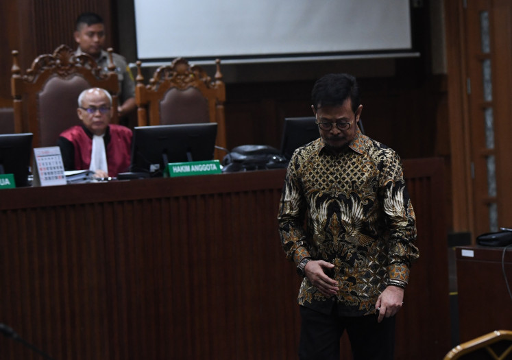 Former agriculture minister Syahrul Yasin Limpo (right), from the NasDem Party, walks to the defendant’s seat during his indictment hearing on Feb. 28, 2024 at the Jakarta Corruption Court. Prosecutors from the Corruption Eradication Commission (KPK) have accused him of soliciting bribes and accepting Rp 44 billion in gratuities.