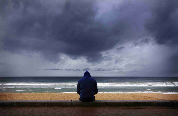 A surfer looks at waves as storm clouds move in from the Pacific Ocean at Sydney's Manly Beach August 26, 2014. The Australian Weather Bureau reported today that despite tropical Pacific Ocean temperatures remaining at neutral levels, models suggest El Nino development remains possible during the coming months, adding that weakening trade winds over the Pacific Ocean earlier in August produced little warming of tropical sea surface temperatures. Picture taken August 26, 2014.      REUTERS/David Gray     (AUSTRALIA - Tags: ENVIRONMENT SOCIETY TPX IMAGES OF THE DAY)