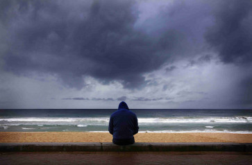 A surfer looks at waves as storm clouds move in from the Pacific Ocean at Sydney's Manly Beach August 26, 2014. The Australian Weather Bureau reported today that despite tropical Pacific Ocean temperatures remaining at neutral levels, models suggest El Nino development remains possible during the coming months, adding that weakening trade winds over the Pacific Ocean earlier in August produced little warming of tropical sea surface temperatures. Picture taken August 26, 2014.      REUTERS/David Gray     (AUSTRALIA - Tags: ENVIRONMENT SOCIETY TPX IMAGES OF THE DAY)