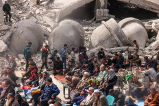 Palestinians attend the Friday noon prayers in front of the ruins of the al-Faruq mosque, destroyed in Israeli strikes in Rafah in the southern Gaza Strip on March 1, 2024, amid continuing battles between Israel and the Palestinian militant group Hamas. 