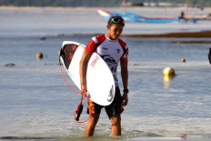 In this file photo, Indonesian surfer Rio Waida walks back from the shore after competing in a 2022 World Surf League (WSL) event on Plengkung Beach in Banyuwangi, East Java, on June 3, 2022.