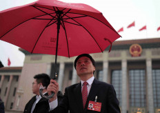 A delegation member leaves the Great Hall of the People amid snowfall after the opening session of the National People's Congress (NPC), in Beijing, China March 5, 2024.