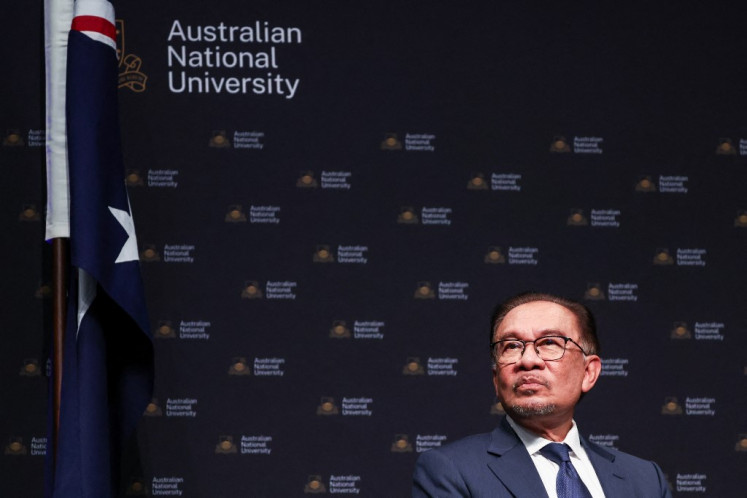 Malaysia's Prime Minister Anwar Ibrahim listens to former Australian Foreign Minister Gareth Evans speak during an event at the Australian National University (ANU) in Canberra on March 7, 2024. 