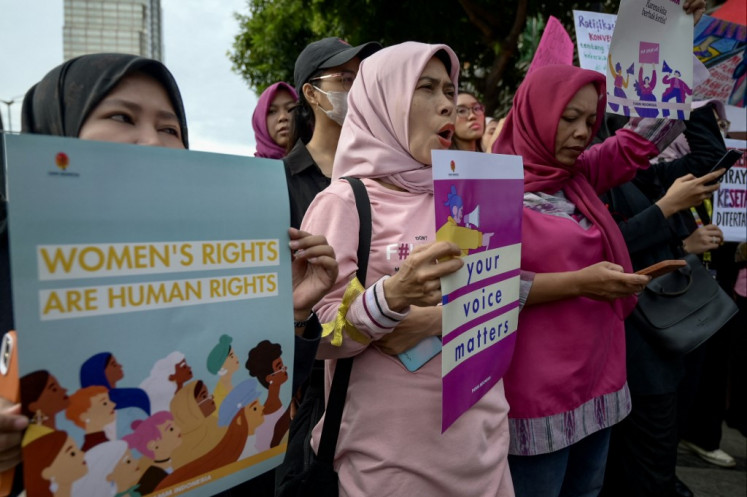 Indonesian women march during a rally on March 8 2024 while commemorating International Women's Day in Jakarta. They demanded the Indonesian government pass plans for an anti-discrimination law and to ratify International Labor Organization (ILO) convention number 190 of 2019 concerning the elimination of sexual violence and harassment at work.