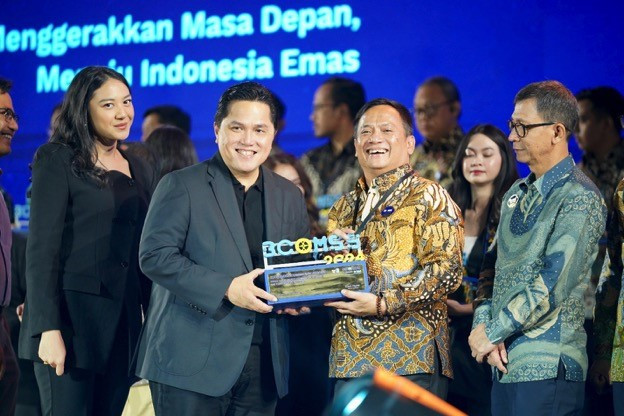 State-Owned Enterprises (SOEs) Minister Erick Thohir (center left) presents the Top Contributor to SOEs for Communications award to PT Permodalan Nasional Madani (PNM) CEO Arief Mulyadi (center right) during the State-Owned Enterprises Corporate Communication and Sustainability Summit (BCOMSS) 2024 on Thursday in Jakarta.