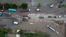 Vehicles make their way along flooded streets in Semarang, Central Java, on March 13, 2024. Heavy rain and overflowing waterways in the coastal city triggered flooding of up to 1.5 meters deep and disrupted traffic on one of Java’s busiest highways.