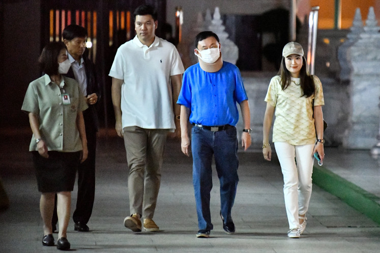 Thailand's former prime minister Thaksin Shinawatra (second right)
walks next to his daughter Paetongtarn Shinawatra on March 14, 2024, as they arrive to pay their
respect at the City Pilar Shrine in Bangkok, before visiting his hometown in Chiang Mai
province for the first time since he fled the country after a military coup in 2006.