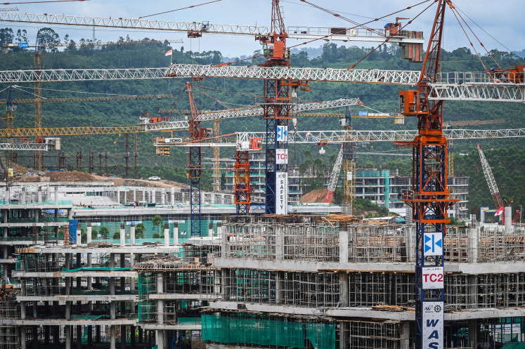 Cranes and scaffolds stand on Feb. 12, 2024 as construction progresses at the site of the Central Government District (KIPP) in the country’s new capital Nusantara, under development in North Penajam Paser regency, East Kalimantan.
